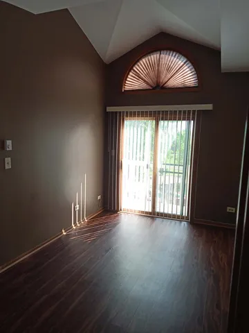 an empty room with wooden floor and a floor to ceiling window