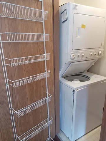 a utility room with wooden floor and white cabinet