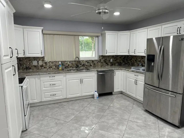 a kitchen with white cabinets stainless steel appliances and a counter space