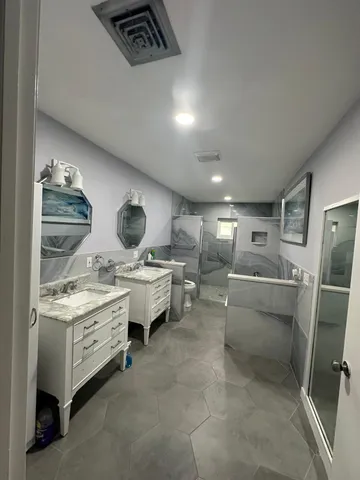 a room with stainless steel appliances kitchen island granite countertop furniture and a view of living room