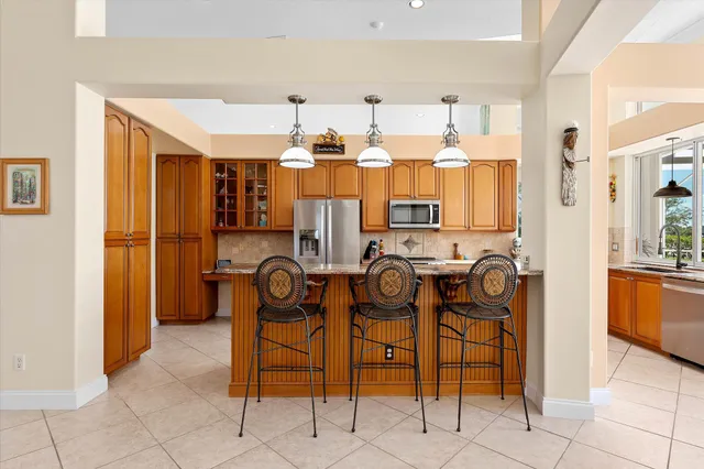 a dining room with furniture large windows and a chandelier
