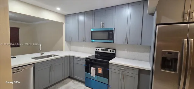 a kitchen with a sink appliances and cabinets