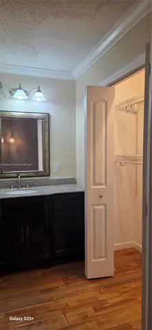a view of a livingroom with wooden floor and a kitchen space