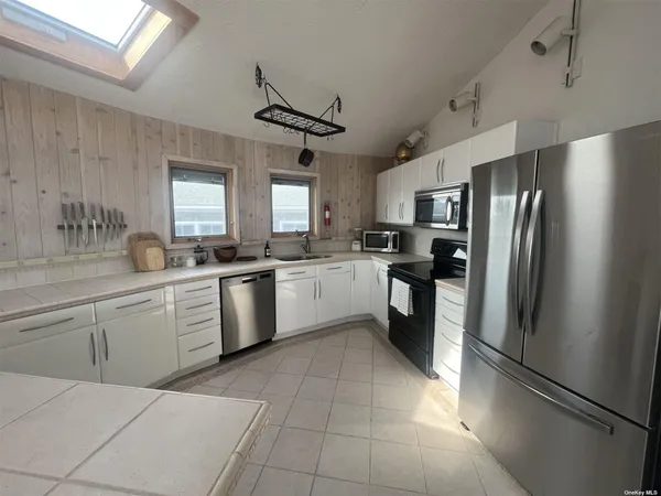 a kitchen with a refrigerator sink and cabinets
