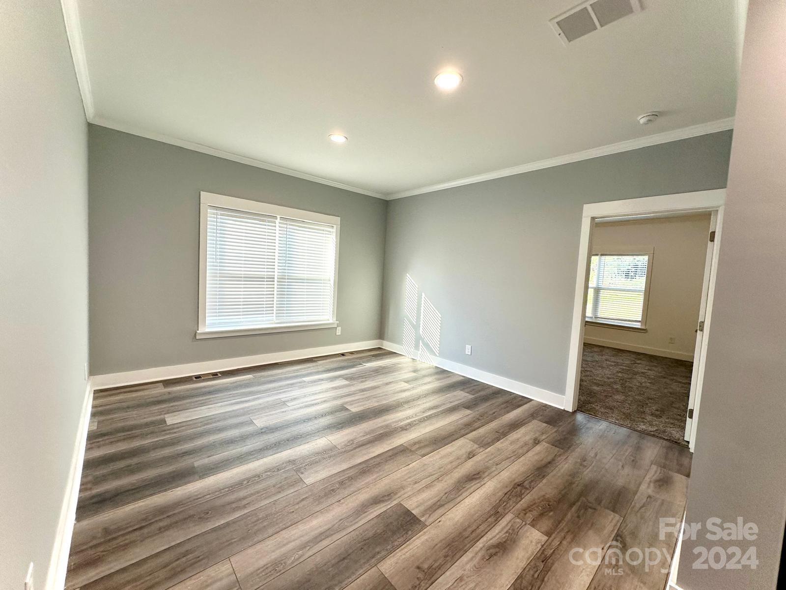 4847 Charlie Crawley Road, Unit 2 Morganton, NC 28655 - Photo 17 of 36 an empty room with wooden floor and windows