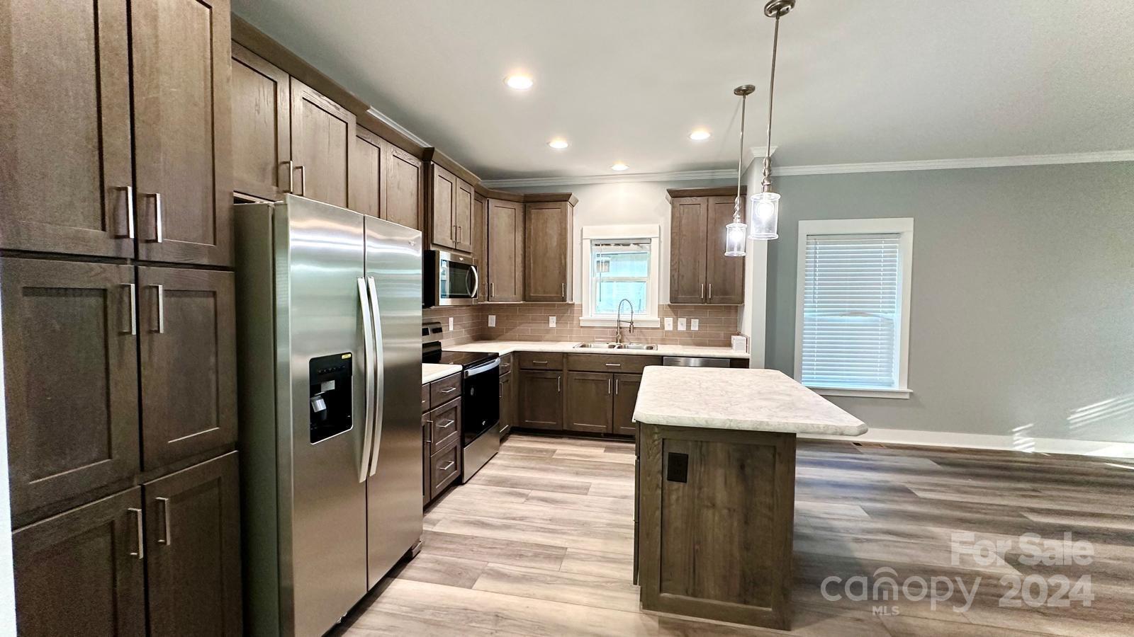 4847 Charlie Crawley Road, Unit 2 Morganton, NC 28655 - Photo 8 of 36 a kitchen with stainless steel appliances kitchen island granite countertop a refrigerator a sink and a wooden floor