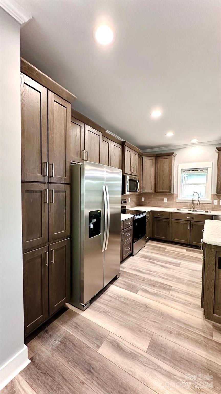 4847 Charlie Crawley Road, Unit 2 Morganton, NC 28655 - Photo 10 of 36 a kitchen with stainless steel appliances wooden floor sink and refrigerator