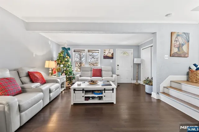 a living room with granite countertop furniture a rug kitchen view and a large window