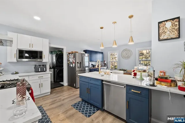 a very nice looking kitchen with granite countertop a stove a sink dishwasher and a wooden cabinets