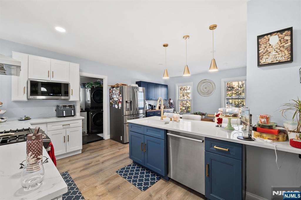 71 Spring Street Nutley, NJ 07110 - Photo 17 of 50 a kitchen with stainless steel appliances kitchen island granite countertop a sink dishwasher stove and wooden cabinets