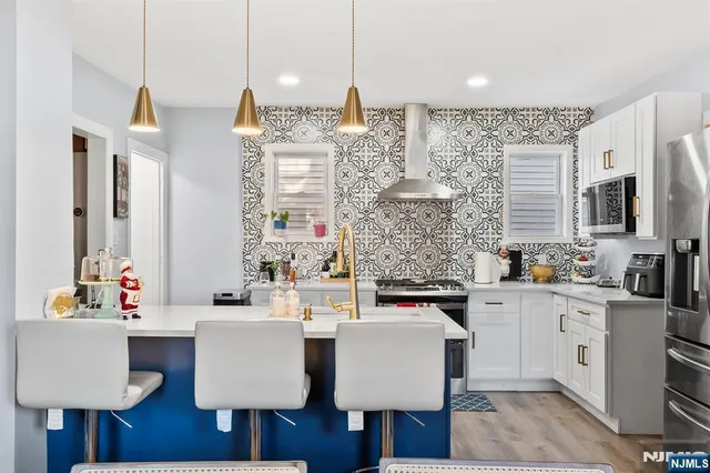 a kitchen with kitchen island a dining table chairs sink and cabinets