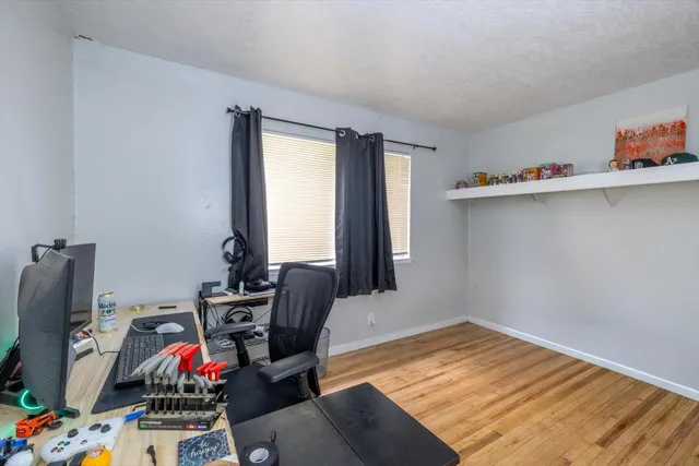 a view of a workspace with furniture and wooden floor