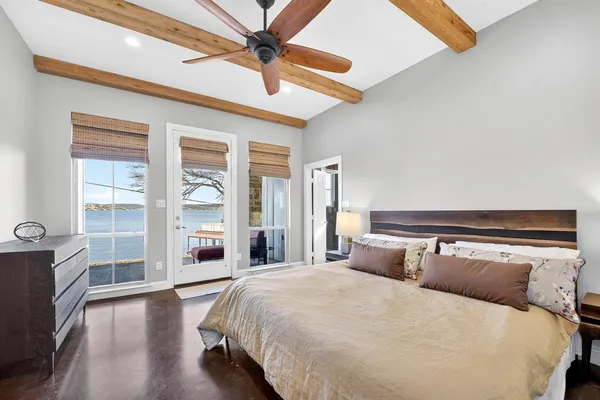 a bedroom with a large bed and a chandelier fan