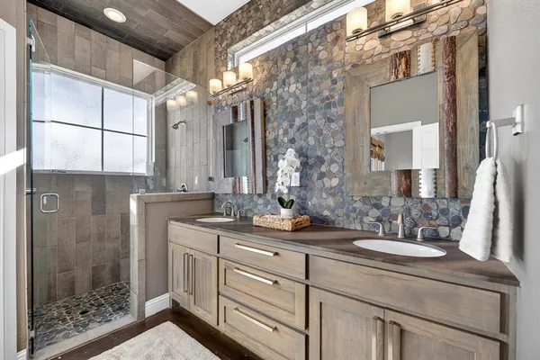 a bathroom with a double vanity sink mirror and shower