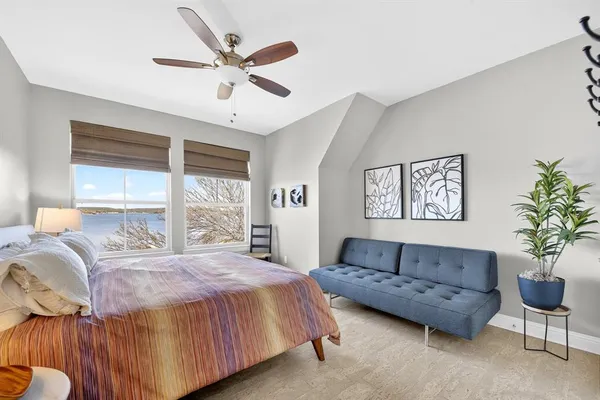 a spacious bedroom with a bed couch and window