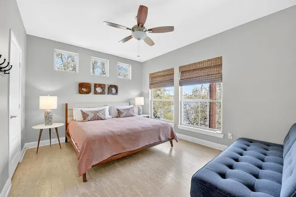 a bedroom with a bed and furniture with a large window