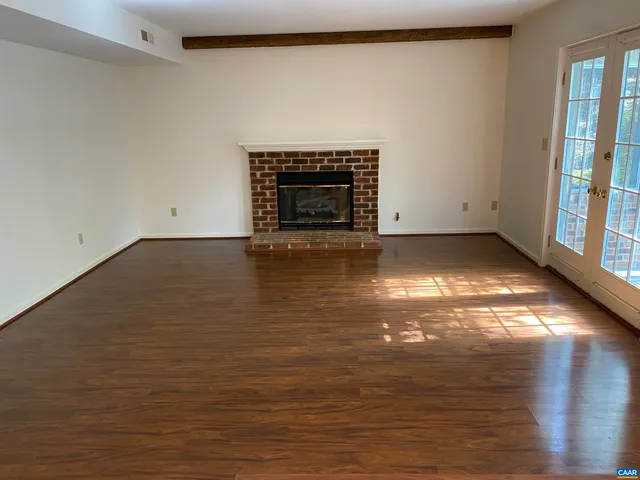 a view of empty room with wooden floor and fireplace