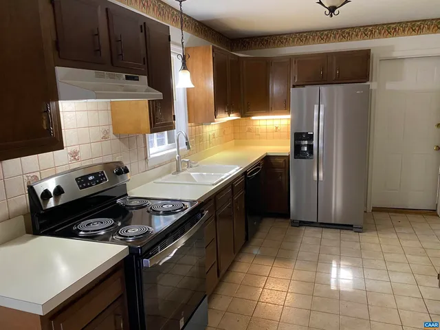 a kitchen with a stove cabinets and refrigerator