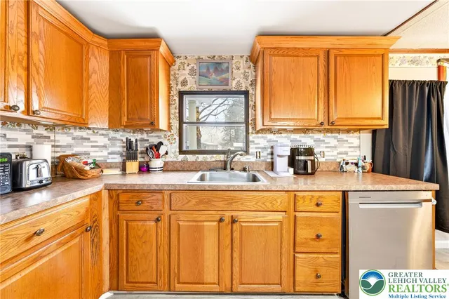 a kitchen with stainless steel appliances granite countertop a sink a stove a refrigerator and cabinets