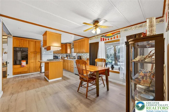 a view of a dining room with furniture a chandelier and kitchen view