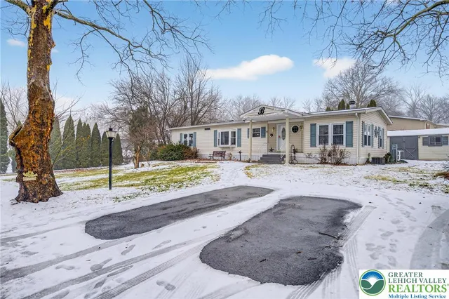 a view of a white house with a yard covered in snow