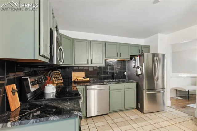 a kitchen with stainless steel appliances granite countertop a refrigerator and a stove top oven