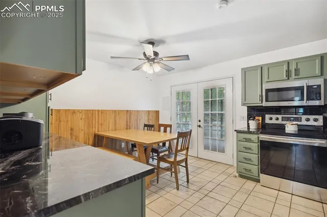 a kitchen with stainless steel appliances kitchen island granite countertop a table chairs and a refrigerator