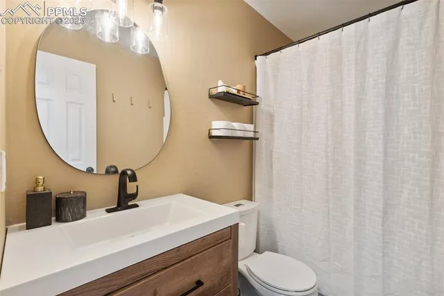 a bathroom with a sink vanity mirror and toilet
