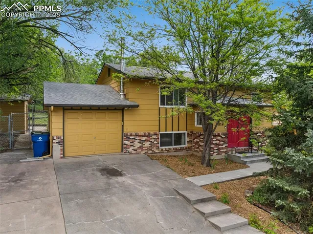 a view of a patio with table and chairs and a large tree