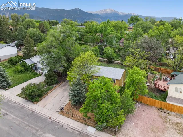 an aerial view of a house with a yard and mountain view in back