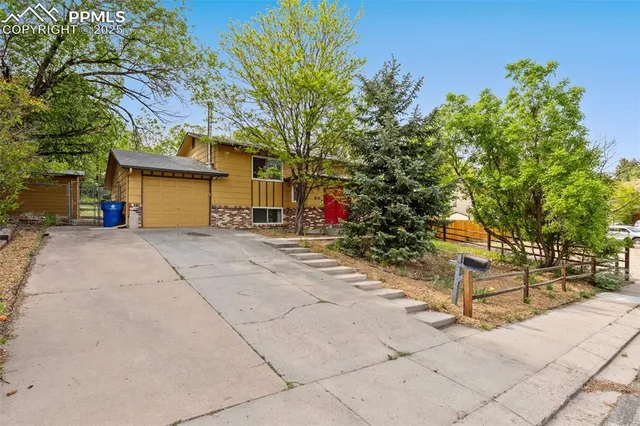 a view of a house with a tree next to a yard