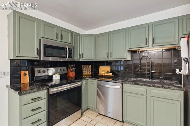 a kitchen with granite countertop a stove top oven microwave and cabinets