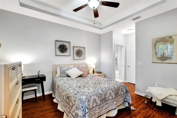 a bedroom with a bed wooden floor and lamp