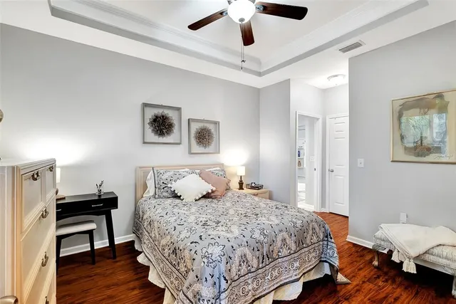 a bedroom with a bed wooden floor and lamp