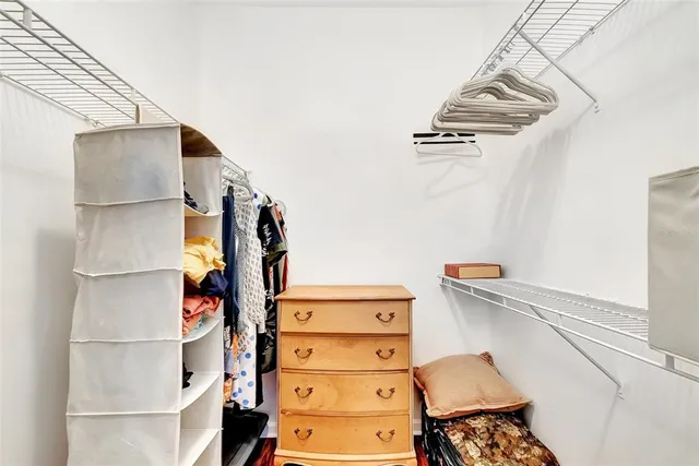 a view of walk in closet with clothes and shoes