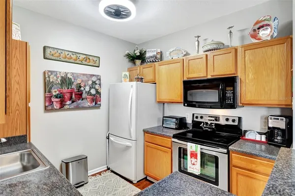 a kitchen with stainless steel appliances granite countertop a refrigerator a stove top oven a sink and dishwasher