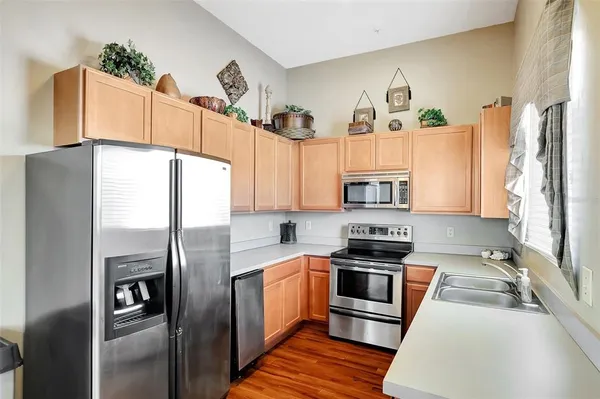 a kitchen with granite countertop a refrigerator oven a sink and dishwasher