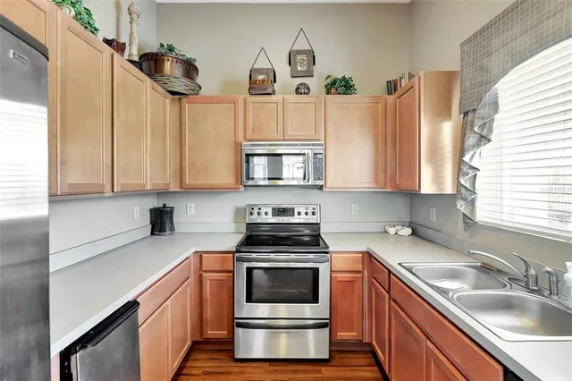 a kitchen with cabinets appliances and a window