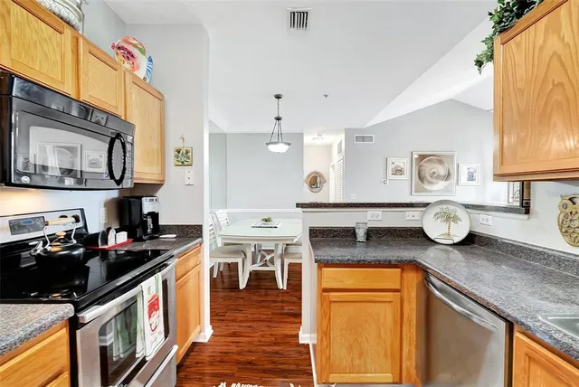 a kitchen with stainless steel appliances granite countertop a stove a sink and a microwave