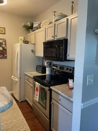 a kitchen with stainless steel appliances a refrigerator a stove and a sink with wooden floor