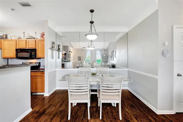 a view of a dining room with furniture a chandelier and wooden floor