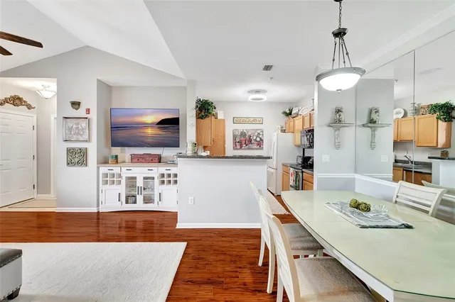a dining room with wooden floor and chandelier