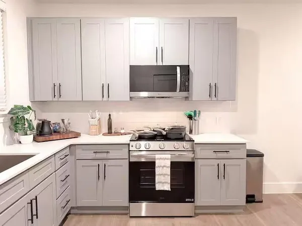 a kitchen with stainless steel appliances granite countertop a stove a sink and a white cabinets