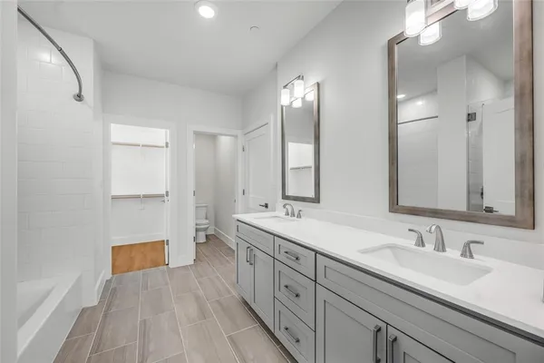 a spacious bathroom with a double vanity sink and mirror