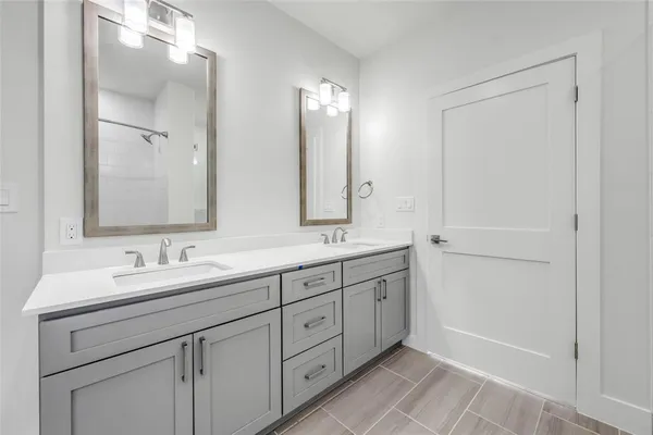 a bathroom with double sink and a mirror
