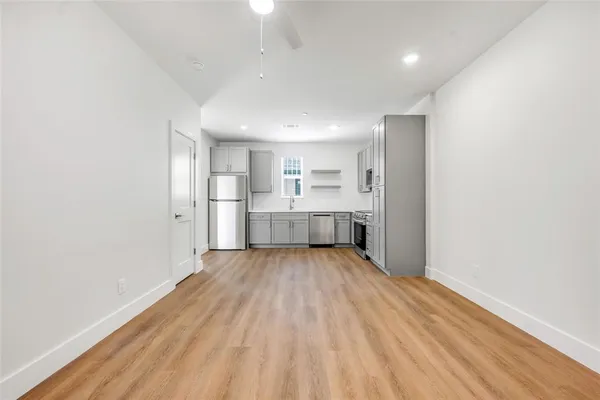 a view of a room with wooden floor and kitchen