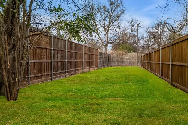 a view of a backyard with a small cabin and wooden fence