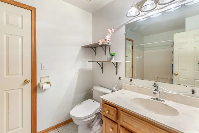 a bathroom with a sink vanity mirror and toilet