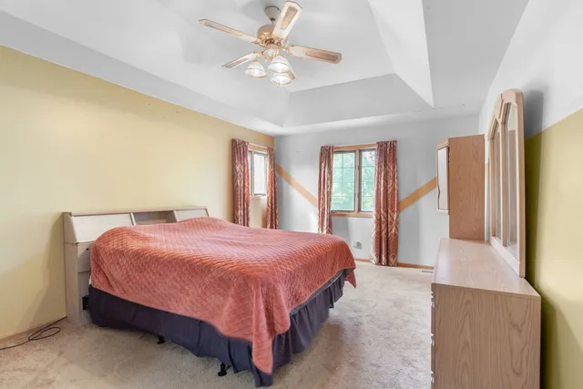 a bedroom with a large bed and a chandelier