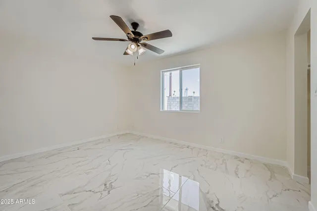 an empty room with windows and fan